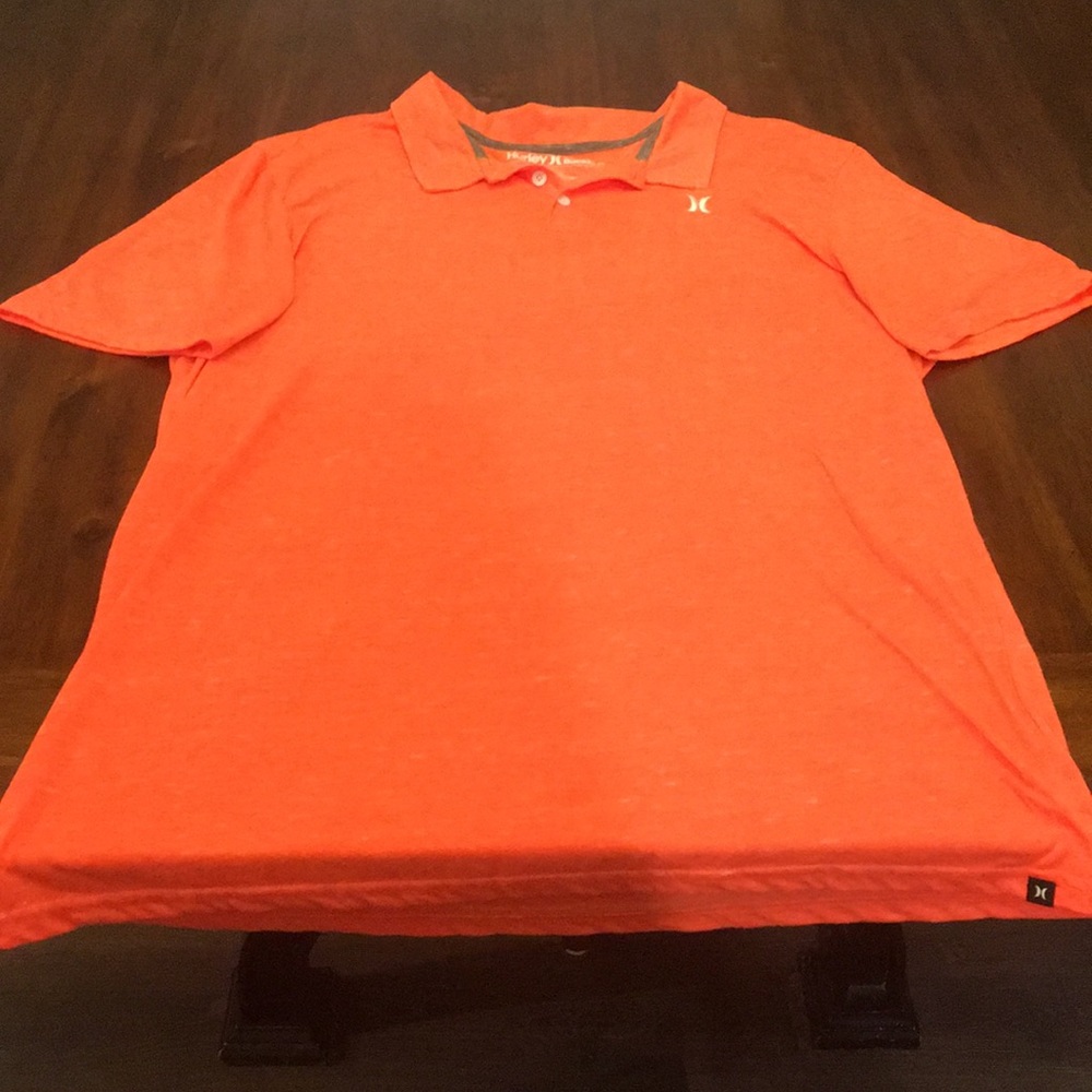 Coral colored short sleeve collared Hurley shirt.